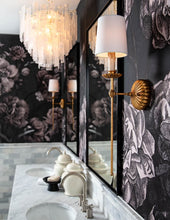 Load image into Gallery viewer, This sconce exudes a sense of opulence with its antique gold leaf finish on the backplate, bobeches, and elongated stem. The candle, reminiscent of antique designs, supports a modern shade. Whether in modern or traditional interiors, the Clove sconce will add a touch of elegance, making it perfect for flanking a fireplace in a living room.