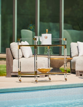 Load image into Gallery viewer, Featuring a sleek design, this bar cart boasts clear acrylic, clear tempered glass shelves, and polished brass finished iron edging. It is the perfect choice for all your essential entertaining needs.
