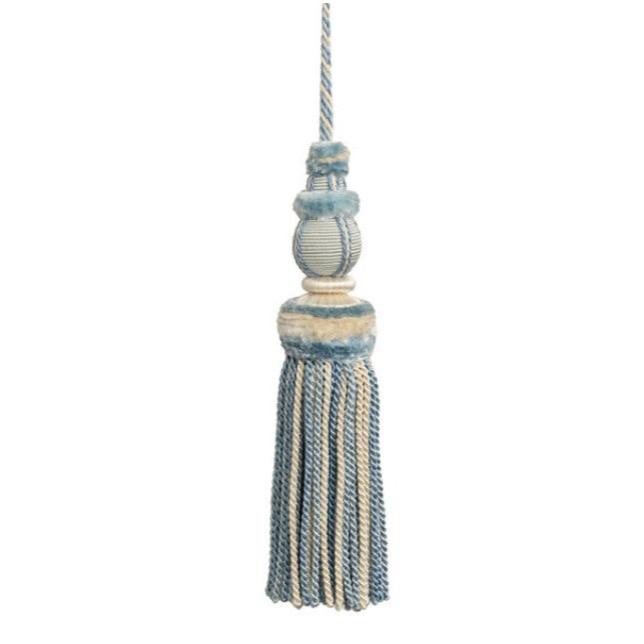 This key tassel adds a touch of history, romance, and texture with its soft hydrangea blue and cream color. Made from soft thread, it can be used to add an intriguing element to lamp pulls, cabinetry knobs, drapery, pillows, and more. Its versatile use makes it a perfect addition to any interior design. 