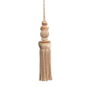 This key tassel adds a touch of history, romance, and texture with its soft pink petal and cream color. Made from soft thread, it can be used to add an intriguing element to lamp pulls, cabinetry knobs, drapery, pillows, and more. Its versatile use makes it a perfect addition to any interior design. 