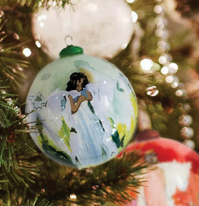 Elevate your holiday decor with Anne Neilson's exclusive, limited edition Christmas ornaments. Each one is meticulously hand-painted from an original Anne Neilson artwork, making them a unique fusion of art and festive spirit. Share these treasured ornaments with loved ones or keep them as luxurious keepsakes. Ornament is a 3" glass ball with gold ribbon.