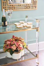 Load image into Gallery viewer, Featuring a sleek design, this bar cart boasts clear acrylic, clear tempered glass shelves, and polished brass finished iron edging. It is the perfect choice for all your essential entertaining needs.
