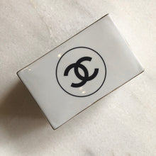 Load image into Gallery viewer, Impress your connections with this ceramic notecard box adorned with a chic fashion insignia. Accompanied by a set of matching notecards, this set is the epitome of tasteful luxury and elegance. It&#39;s the perfect way to leave a lasting impression with your personal touch.
