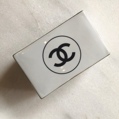 Impress your connections with this ceramic notecard box adorned with a chic fashion insignia. Accompanied by a set of matching notecards, this set is the epitome of tasteful luxury and elegance. It's the perfect way to leave a lasting impression with your personal touch.