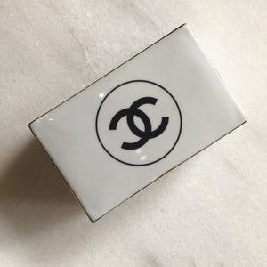 Impress your connections with this ceramic notecard box adorned with a chic fashion insignia. Accompanied by a set of matching notecards, this set is the epitome of tasteful luxury and elegance. It's the perfect way to leave a lasting impression with your personal touch.