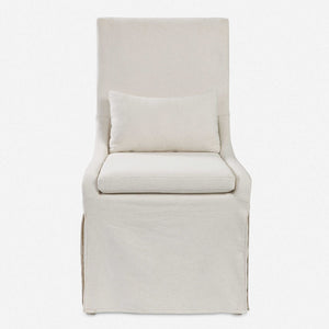 Crafted with simplicity in mind, this refined armless dining chair boasts a fitted slipcover in a neutral off-white linen blend. Its seat is cushioned for ultimate comfort and comes with an accompanying kidney pillow. The added performance treatment also makes it resistant to stains and soiling, ensuring long-lasting use.