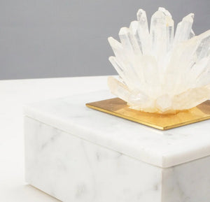 This elegant marble jewelry box is expertly hand-crafted, adding a touch of sophistication to any dressing table. Featuring a cluster of natural Brazilian clear quartz points, it serves as both a luxurious storage option and incorporates the healing and energizing qualities of quartz into your jewelry collection.