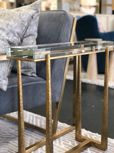 Load image into Gallery viewer, Experience true luxury with the exquisite Midas Accent Table. Crafted with textured antique gold finish iron legs, this table expertly supports a thick crystal top for an elegant touch to any room.
