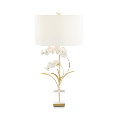 The Perse table lamp is a remarkable blend of natural elements and contemporary aesthetics. Elaborate porcelain petals are expertly crafted and upheld by slender brass stems finished in gold leaf. The lamp stands on a base made of clear crystal and adorned with brass accents. A polished brass neck, along with a floral porcelain finial, adds the perfect finishing touch. Features a convenient three-way switch.