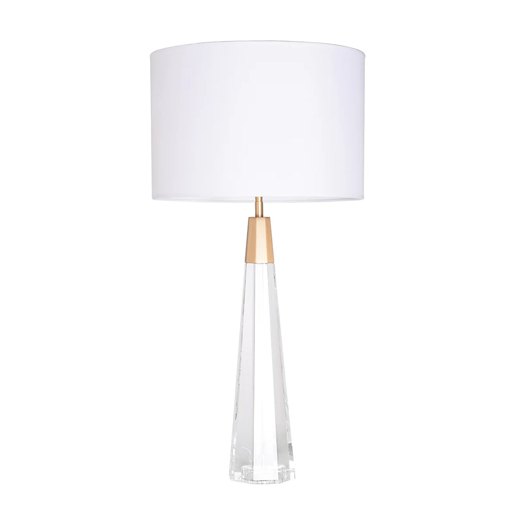 Our Monroe table lamp is a combination of simplicity and timelessness, featuring a clear crystal column paired with brushed brass accents. It's the perfect addition to any transitional, modern, or traditional interior. The faceted base and white linen circular drum shade create a balanced look, while the clear glass adds a touch of brightness and spaciousness to any room.