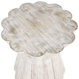 The Annie Side Table features a light washed woodgrain texture, an hourglass silhouette, and a scalloped flower shape. These elements add a touch of femininity and textural interest to the table.