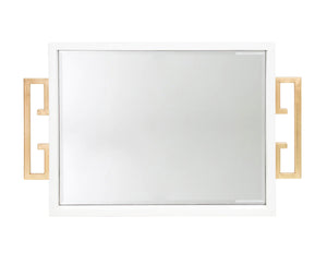 The Avana Tray features a high gloss lacquer finish in black or white, accompanied by a beveled mirror inset and gold leaf iron handles on the sides, making it both decorative and functional.