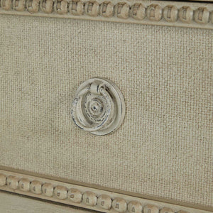 French-style 18th century inspired chest with beaded burlap drawer fronts and carved legs, with an antiqued white finish