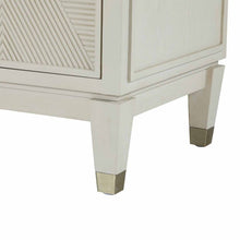 Load image into Gallery viewer, Close-up of legs on contemporary ribbed-front cabinet in a white cerused finish with champagne hardware accents.
