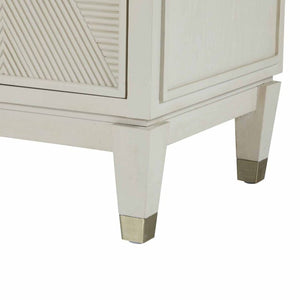 Close-up of legs on contemporary ribbed-front cabinet in a white cerused finish with champagne hardware accents.