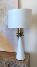 Load image into Gallery viewer, The Anemone Table Lamp features a unique design with its elegant tapered silhouette and distinctive anemone accent. The painted card cylinder shade pairs perfectly to add a touch of elegance to any room.
