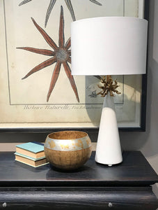 The Anemone Table Lamp features a unique design with its elegant tapered silhouette and distinctive anemone accent. The painted card cylinder shade pairs perfectly to add a touch of elegance to any room.